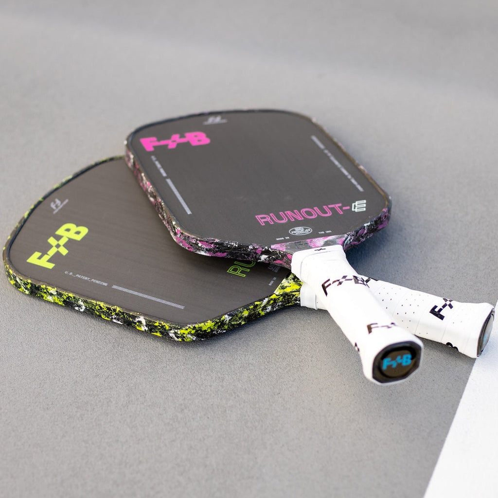 Two pickleball paddles with 'F+B' branding on a gray surface.