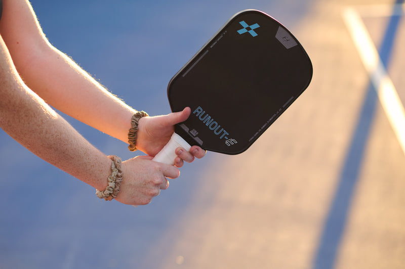 Person holding the F+B Runout - Elongated Carbon Fiber Pickleball Paddle