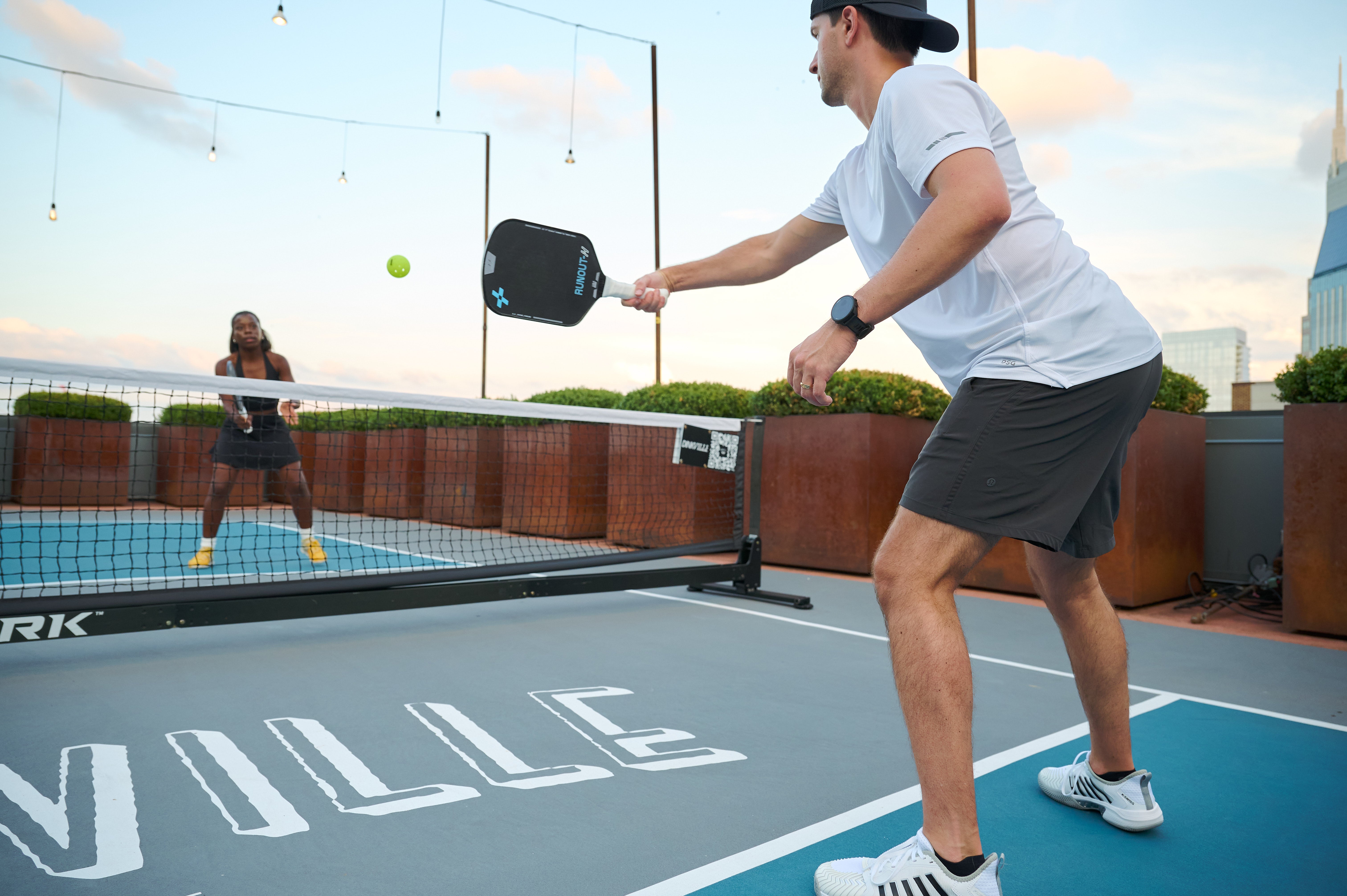 Two people playing pickleball with the F+B Runout Series Carbon Fiber Pickleball Paddles