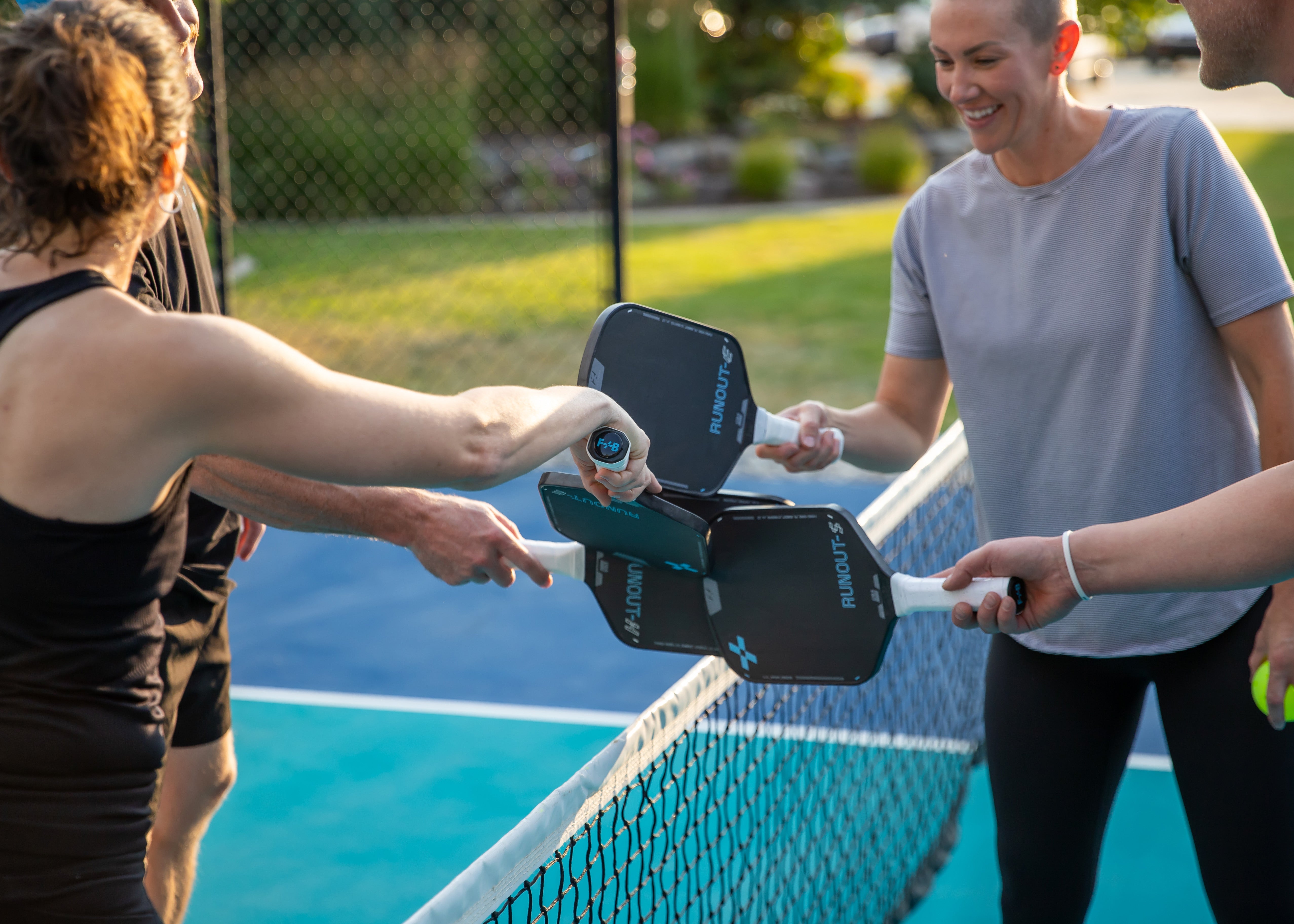 People on a pickleball court with F+B carbon fiber pickleball paddles